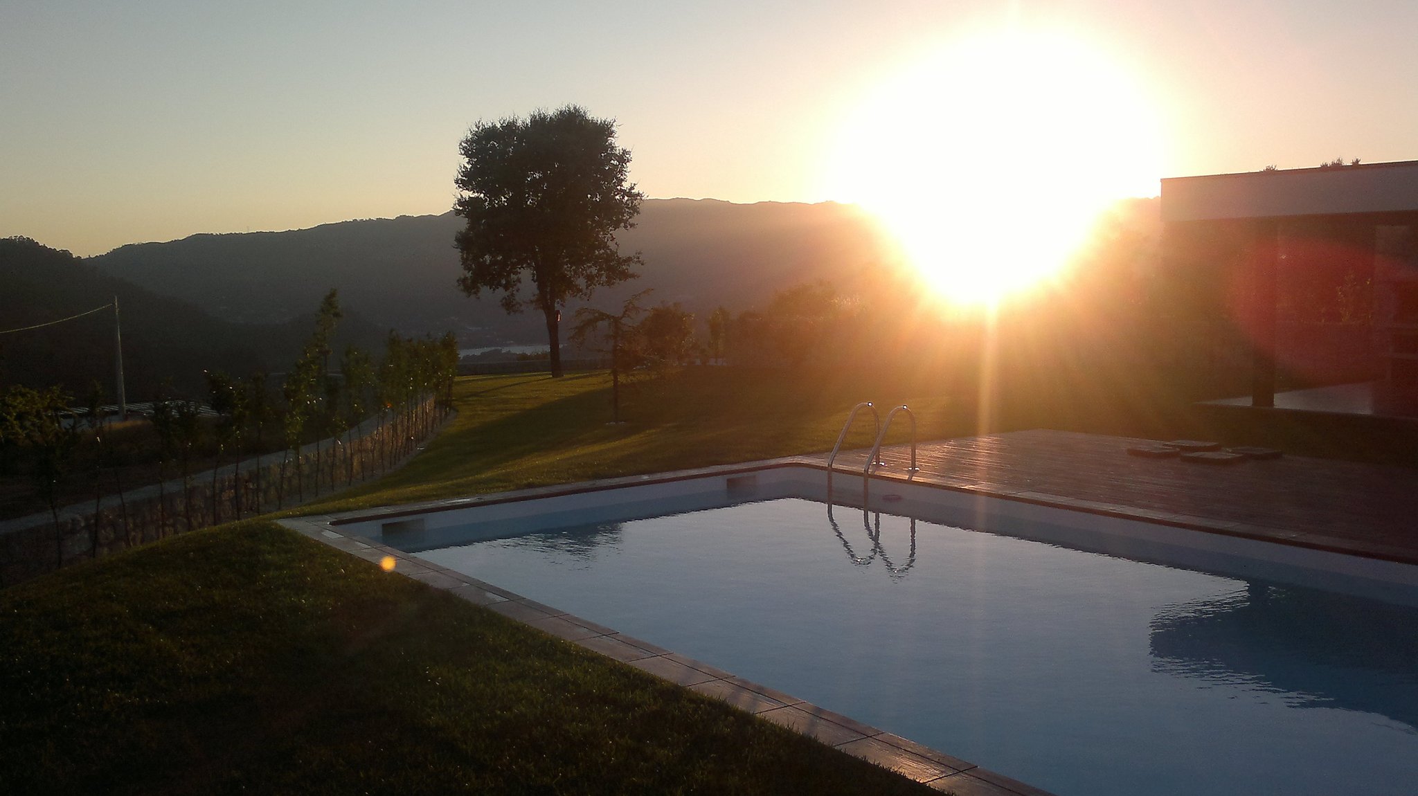 Piscina al atardecer con las montañas de fondo