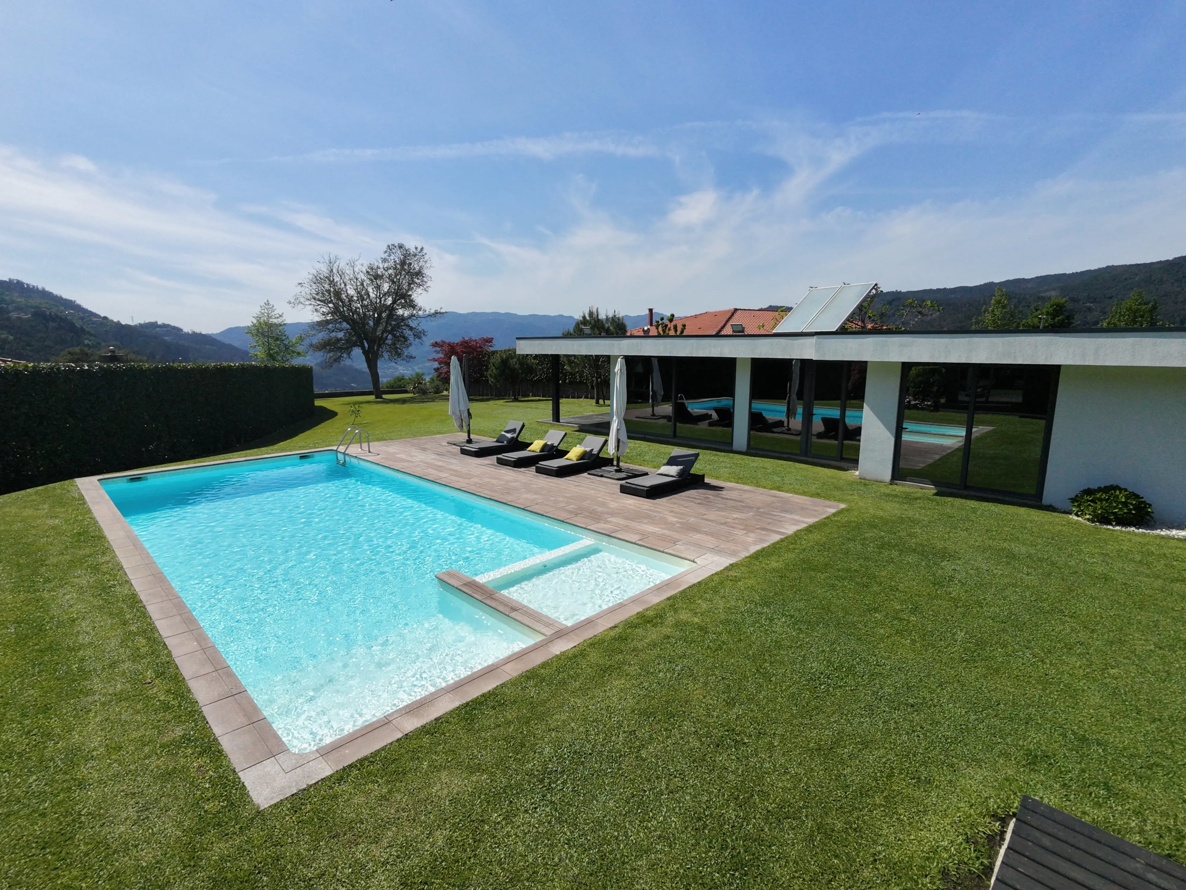 Piscina con tumbonas y terraza cubierta